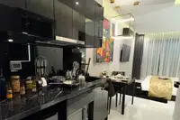 Studio Condo for Sale at Grand Solaire Noble: Modern kitchenette with black marble countertop, sleek cabinets, and dining area.