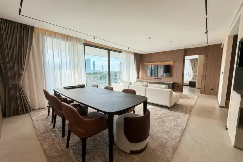3 Bedroom Condo for Rent at Panora Estuaria spacious open-plan dining and living area with dark 8-seat dining table and panoramic city views
