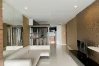 3 Bedroom Condo for Sale at Apus spacious living room with white L-shaped sofa, TV unit, and gold floral accent wall