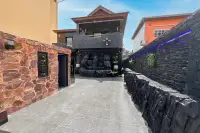 3 Bedroom House for Sale in Bang Lamung dramatic stone entrance driveway with black rock waterfall feature and two-storey facade