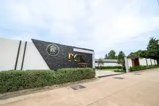 PCK Villa branded entrance gate with black stone signage, trimmed hedges and gated driveway in Pattaya