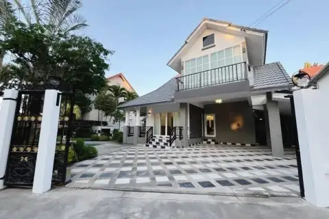 5 Bedroom House for Sale at Central Park 4. Front exterior of the house with a patterned driveway and ornate gate.
