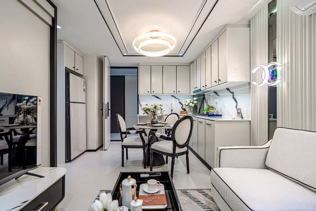 2 Bedroom Condo for Sale at Embassy Life, open-plan living room with white sofa, dining area, and modern kitchen.