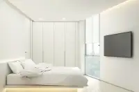 2 Bedroom Condo for Sale at Secret Garden Condominium, bedroom with built-in wardrobes, large window, and wall-mounted TV.