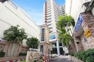 Sriracha Condo View entrance driveway with palm trees and high-rise tower in Pattaya