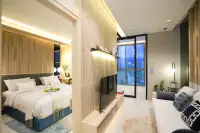 1 Bedroom Condo for Sale at SKYPARK Lucean Jomtien Pattaya spacious living area with open bedroom, wood panel divider, sofa and floor-to-ceiling city view