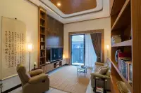 3 Bedroom House for Sale at Amarin House 2 living room with leather recliner, TV wall unit, wood ceiling, and calligraphy scroll