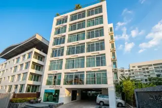 South Beach Condominium exterior showing the multi-story white building with large windows and ground floor entrance.