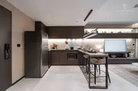 1 Bedroom Condo for Sale at Panora Estuaria: Contemporary kitchen with dark cabinetry, integrated appliances, and dining bar.