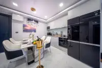 2 Bedroom Condo for Sale at Grand Solaire Noble dining area with marble table and modern kitchen with black built-in appliances