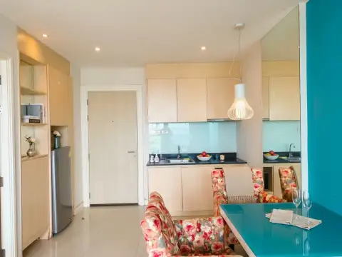 1 Bedroom Condo for Sale at Grande Caribbean kitchenette with wood cabinets, dining table, and entry door