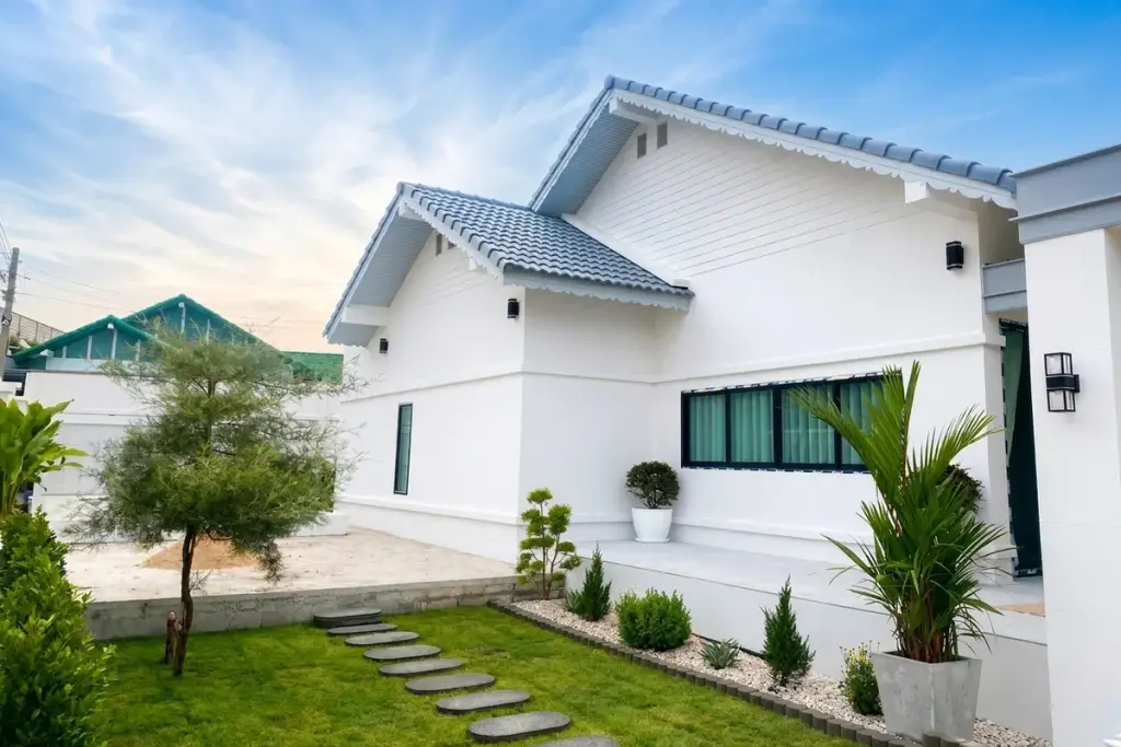 3 Bedroom House for Sale at Paradise Hill 2 white exterior with blue tile roof, manicured garden, and stepping stone pathway