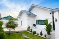 3 Bedroom House for Sale at Paradise Hill 2 white exterior with blue tile roof, manicured garden, and stepping stone pathway