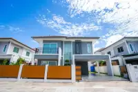 3 Bedroom House for Sale at Baan Pruksa Nara Chaiyapruek two-storey grey exterior with wooden fence and carport under blue sky