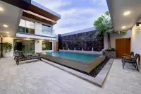 6 Bedroom House for Sale at M Mountain Village raised pool with jet fountains, black pebble surround, palm tree, and spacious tiled courtyard