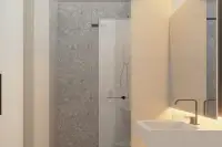 1 Bedroom Condo for Sale at Celine Wongamat bathroom with terrazzo tile shower enclosure, glass partition and gold faucet vanity