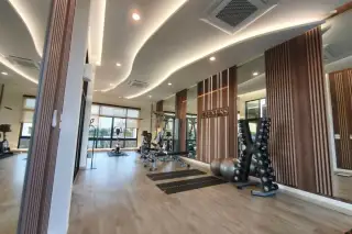 Supalai Palm Ville Sukhumvit - Rongpo modern fitness room with various gym equipment, mirrors, and wood-paneled walls.