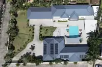 8 Bedroom House for Sale in Pong full aerial view of property with solar panels, pool, and landscaped palm garden