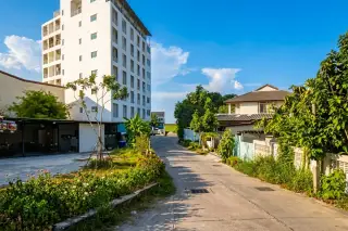 Beach Mountain 4 street view showing the white condo building, power lines, and a narrow road with greenery.
