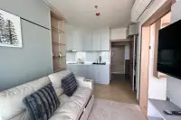2 Bedroom Condo for Sale at The Twin Tower Jomtien Beach Pattaya living room with grey sofa and white kitchen cabinets with marble backsplash