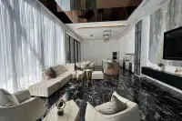 6 Bedroom House for Sale in Bang Lamung open-plan living room with black marble floor and white kitchen.