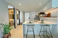1 Bedroom Condo for Sale at Celine Wongamat kitchen breakfast bar with two stools, under-cabinet lighting, and open bathroom view