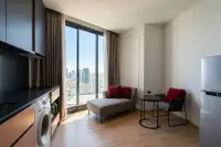 1 Bedroom Condo for Rent at EDGE Central Pattaya open-plan living area with chaise lounge, dining set, and city views