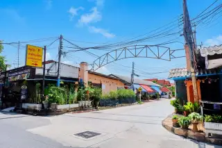 Park Rung Ruang modern two-story house with a separate carport, black gate, and fenced front yard.