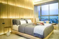 Studio Condo for Sale at SKYPARK Lucean Jomtien Pattaya double bed with backlit wooden slatted headboard wall and ocean view window