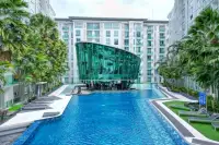 1 Bedroom Condo for Sale at City Center Residence large outdoor swimming pool with glass gym building and tropical palm trees