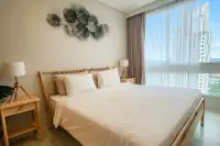 1 Bedroom Condo for Sale at Veranda Residence Pattaya sunlit bedroom with wooden bed frame white bedding and sea view window