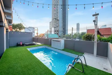 10 Bedroom House for Sale in Bang Lamung private swimming pool with artificial grass lawn, outdoor shower, and city skyline view