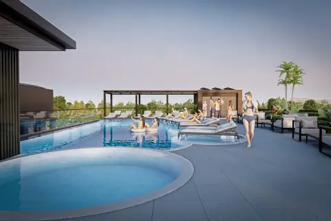 Siam Oriental Beach rooftop swimming pool with a hot tub, lounge chairs, and people relaxing under a clear sky.