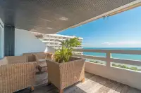 2 Bedroom Condo for Sale at Grand Condotel covered balcony with wicker seating and panoramic sea view in Pattaya