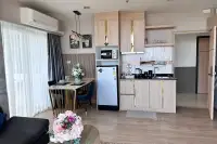 1 Bedroom Condo for Sale at The Twin Tower Jomtien Beach Pattaya open-plan kitchen and dining area with wood cabinets and gold accents