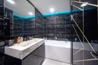 1 Bedroom Condo for Sale at Grand Solaire Noble luxury bathroom with black marble tiles, white bathtub and teal LED lighting