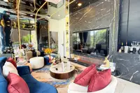 5 Bedroom House for Sale at Harmony Hills Villas Pattaya luxurious living room with black marble feature wall and bar area.