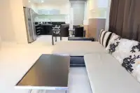 3 Bedroom Condo for Sale at Apus open-plan living and dining area with L-shaped sofa, coffee table, and fitted kitchen beyond