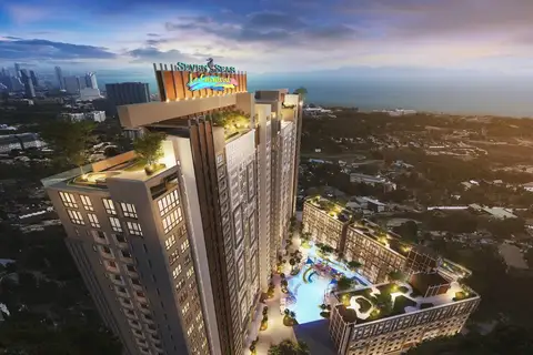 Seven Seas Le Carnival aerial night view of the condo towers, illuminated rooftop sign, and a vibrant water park area.