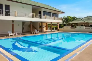 SP Village 3 large communal swimming pool with sun loungers and two-storey clubhouse building