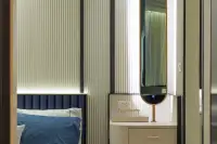 1 Bedroom Condo for Sale at Embassy Life close-up of bedside vanity desk with gold-framed oval mirror and fluted wall panels