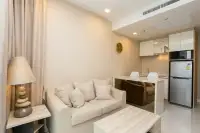 1 Bedroom Condo for Sale at Del Mare open-plan living and kitchen area with white cabinetry, dining bar, and stainless steel refrigerator