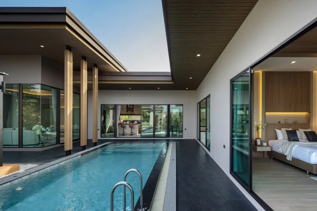 3 Bedroom House for Sale at Baan Pattaya 7 (Ascent) outdoor swimming pool with a modern house facade and visible bedroom.