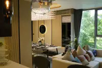 2 Bedroom Condo for Sale at SKYPARK Lucean Jomtien Pattaya luxury living and dining space with crystal chandelier round mirror accent wall and green garden views