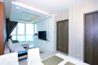 1 Bedroom Condo for Sale at Del Mare spacious living and dining area with striped wallpaper, TV unit, and sea-view balcony