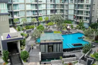 Apus condominium entrance sign with overhead view of courtyard pool, landscaped gardens and sun loungers