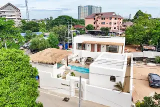 The Sunshine House elevated exterior view with private pool thatched roof and Pattaya neighbourhood surroundings
