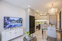 1 Bedroom Condo for Sale at Copacabana Coral Reef living area with TV unit, open kitchen with marble backsplash and crystal chandelier