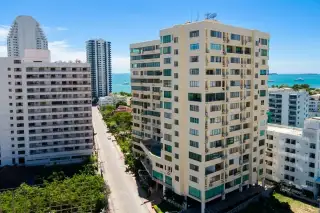 Thepthip Mansion Condominium: Aerial view of the outdoor swimming pool, street, and Pattaya city skyline with distant buildings.