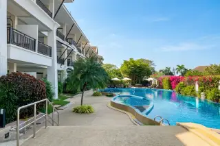 Sunrise Beach Residence outdoor swimming pool with blue mosaic tiles, showing pool entry steps and a white building in the background.